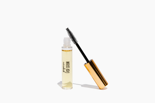 A bottle of Grapevine Lash Serum with a applicator wand and brush, against a white background.